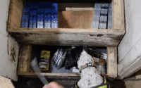 A detection dog uncovers hidden illegal cigarettes and tobacco inside a wooden step compartment during a Trading Standards operation in Blackburn.