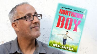 Blackburn-born author Iqbal Hussain holding his novel Northern Boy ahead of his event at Blackburn Central Library